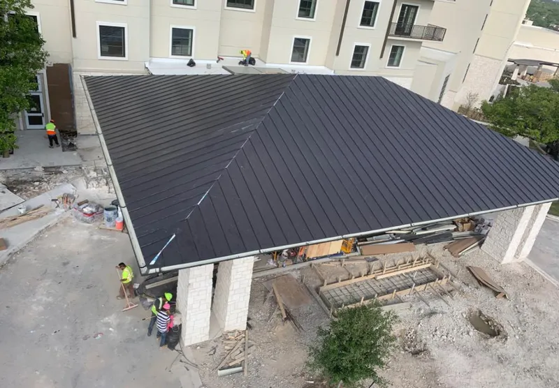 Metal roofing installation team working on a commercial building in Dania Beach